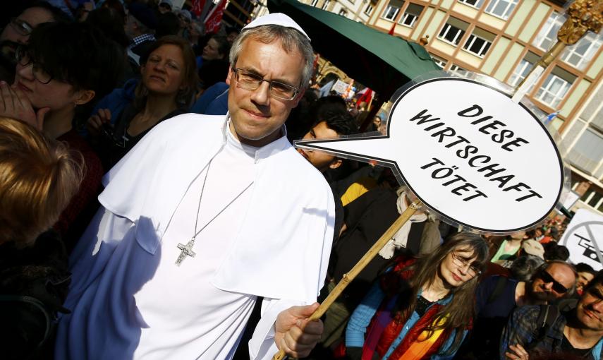 Un manifestante con una pancarta que, en alemán, dice "Esta economía mata", durante la concentración contra las políticas de austeridad en la UE realizada en el centro histórico de Fráncfort, tras la inauguración de la nueva sede del BCE. REUTERS/Kai Pfaf