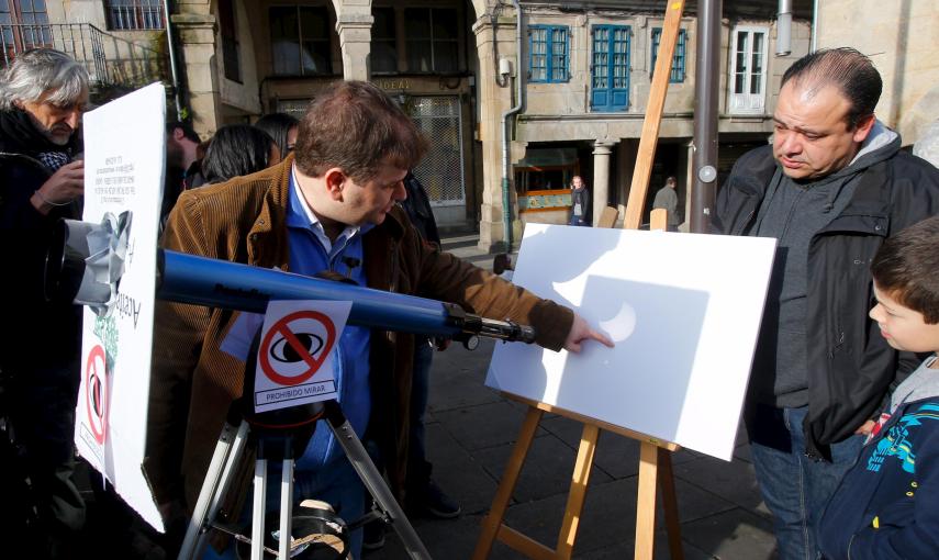 Varias personas en Pontevedra, utilizan un telescopio para observar el eclipse parcial de sol. REUTERS/Miguel Vidal