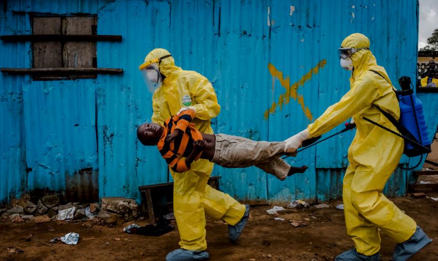 Trabajadores médicos llevan a James Dorbor, 8 años, porque sospechan que pueda tener ébola, a un centro de tratamiento en Monrovia, Liberia./  REUTERS/Daniel Berehulak/The New York Times