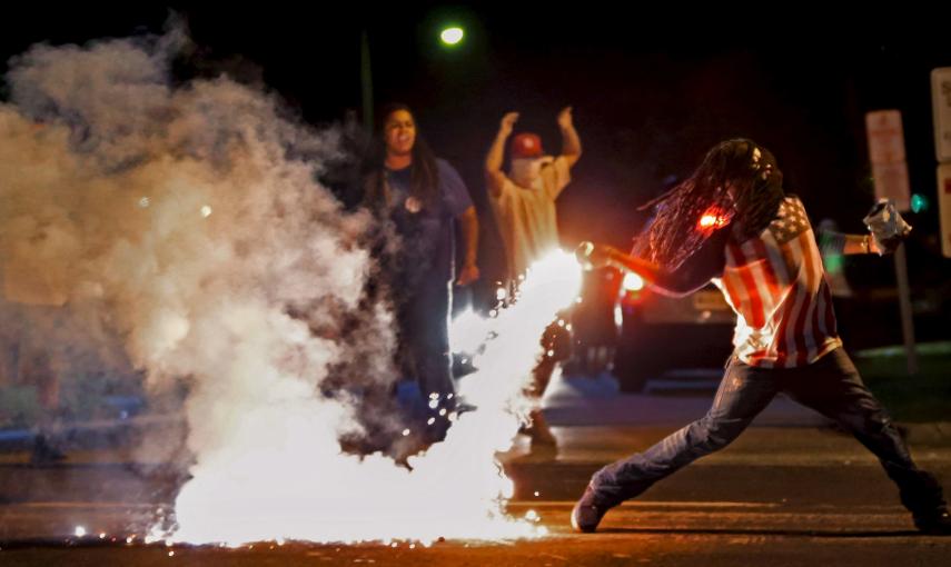 Edward Crawford devuelve un bote de gas lacrimógeno disparado por la policía, que intentaba dispersar la protesta en Ferguson, Mossouri, Estados Unidos./ REUTERS/Robert Cohen/St. Louis Post-Dispatch/Handout