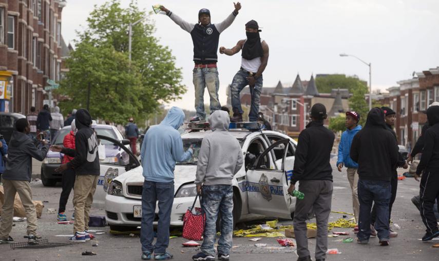 Varios jóvenes se suben a un coche de la policía en medio de las protestas por la muerte de Freddie Grey en Baltimore. EFE