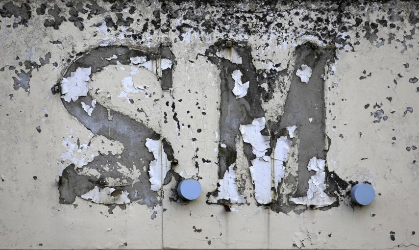 El logotipo destruido de una fábrica textil cerrada en 2003 se ve en la ciudad de Tebas, en la región Sterea Hellas, Grecia.- REUTERS / Yannis Behrakis