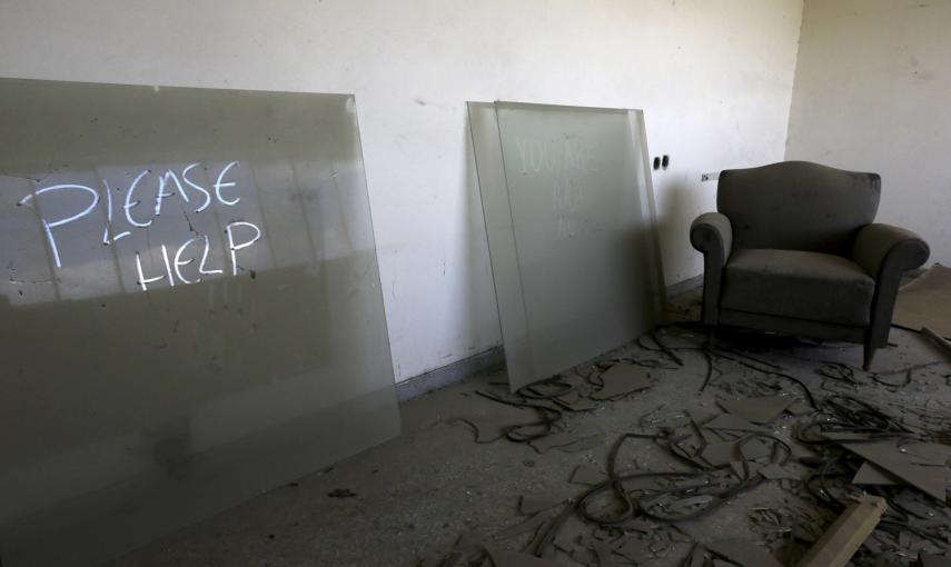 una marca sobre el polvo pide ayuda desde el interior de la oficina de un gerente de una fábrica textil cerrada en 1995 cerca de la ciudad de Larissa en la región de Tesalia, Grecia.- REUTERS / Yannis Behrakis