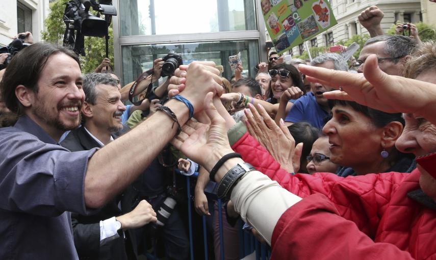 El secretario general de Podemos, Pablo Iglesias, saluda tras asistir en el Ayuntamiento de Madrid a la investidura de la cabeza de lista de Ahora Madrid al Ayuntamiento de la capital, Manuela Carmena, como alcaldesa de Madrid. EFE/CHEMA MOYA