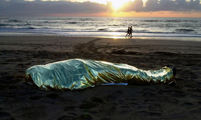 El cadáver de un inmigrante que se ahogó al naufragar su patera, en la plaza de El Matorral, en Fuerteventura.- JUAN MEDINA (REUTERS)