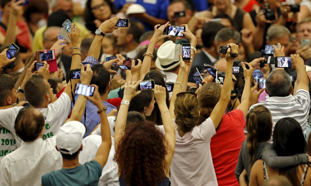 Fieles toman fotografías del Papa Francisco en la sala Pablo VI en el Vaticano, 5 de agosto de 2015. REUTERS / Giampiero Sposito