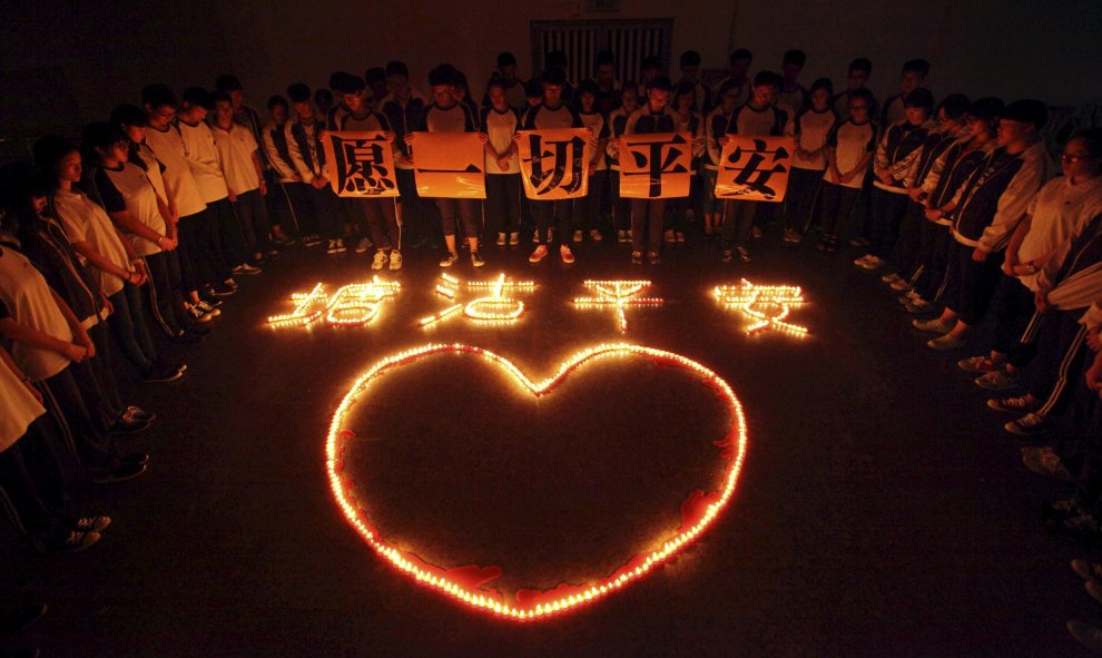 Estudiantes y profesores se juntan para mostrar pancartas de apoyo a los familiares de las víctimas de las explosiones de Tianjin, en una escuela de Zhuji, provincia de Zhejiang, China, 13 de Agosto de 2015. REUTERS / Stringer