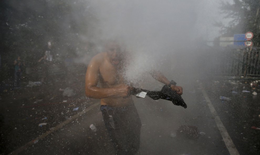 Un migrante es golpeado por un chorro del cañón de agua utilizado por la policía antidisturbios húngara en la parte serbia de la frontera, cerca de Röszke. REUTERS