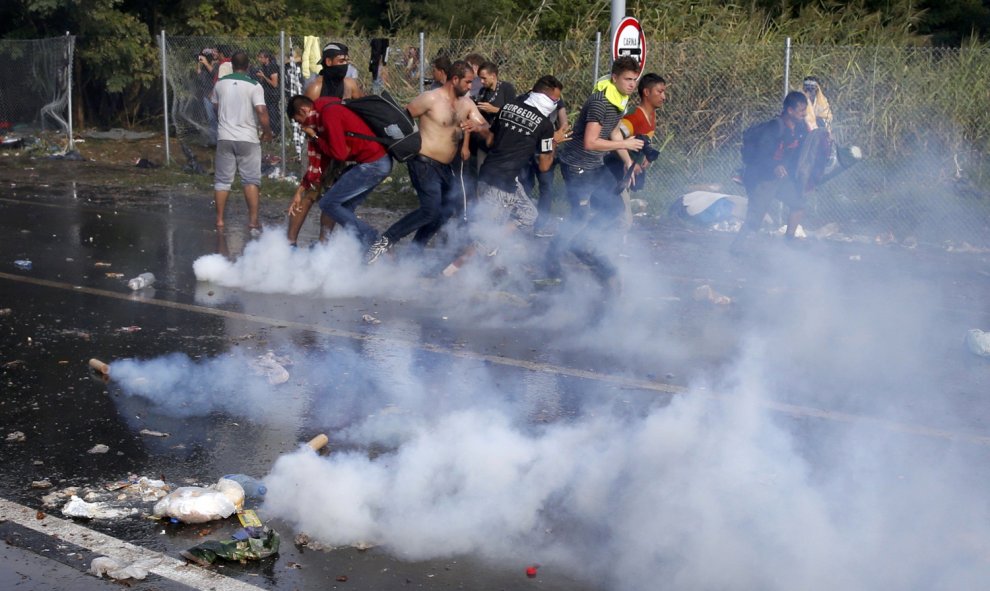 Un migrantes húngaro protesta con un megáfono mientras los antidisturbios húngaros rocían con gases lacrimógenos y cañones de agua a los refugiados. REUTERS