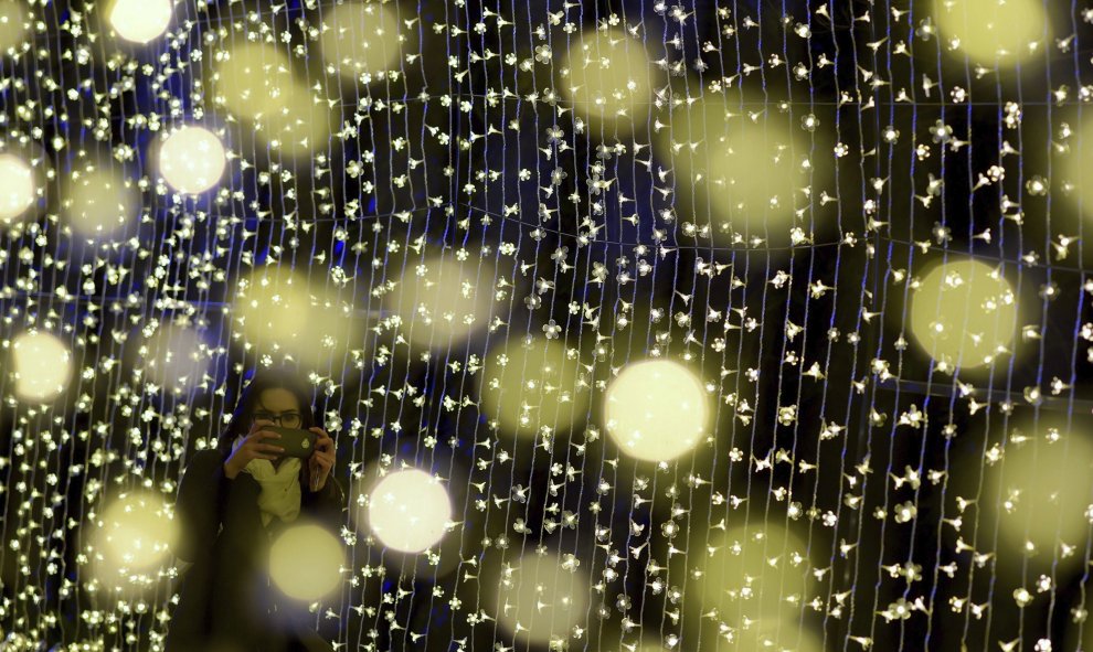 Una mujer fotografía una instalación de luces durante la presentación del NightFest en Canberra (Australia) hoy. El NighFest es parte del festival anual de flores "Floriade" que se celebra del 23 al 27 de septiembre. EFE/Lukas Coch