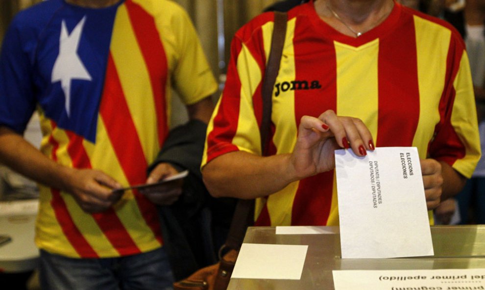 Una ciudadana deposita su voto en una mesa de en un colegio electoral de Barcelona, en las elecciones del 27-S. EFE/ Quique García