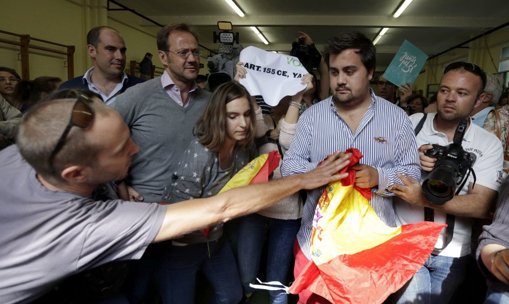 Un a persona trata de arrebatar una bandera a un miembro de VOX en el colegio donde acudió a votar en las elecciones que se celebran en Catalunya, el presidente de la Generalitat y número cuatro en las listas de Junt pel Si, Artur Mas, EFE/Alberto Estévez