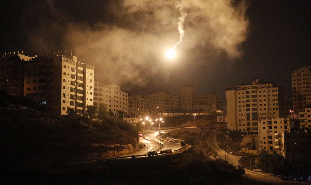 Una llamarada ilumina el cielo de la ciudad vieja de Jerusalén mientras jóvenes palestinos se enfrentan con las fuerzas de seguridad israelíes, el 5 de octubre de 2015. AFP / ABBAS MOMANI