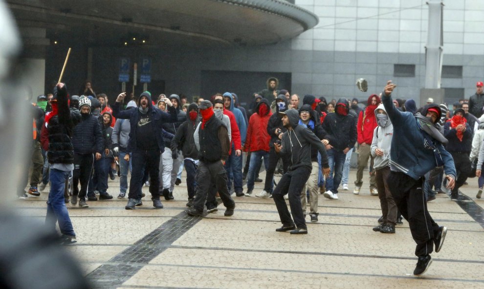 Un manifestante lanza piedras contra la Policía durante una manifestación contra la austeridad en Bruselas.- REUTERS/Yves Herman