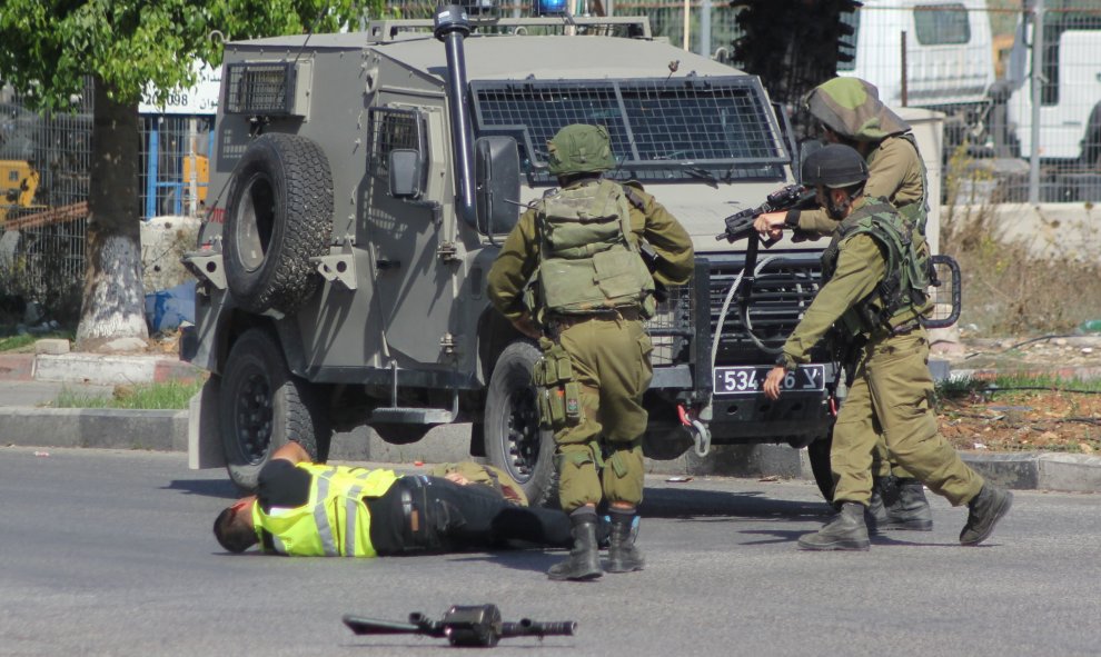 Un atacante palestino, vestido de periodista, apuñala a un soldado israelí antes de caer fulminado por los disparos del Ejército hebreo cerca de la ciudad de Hebrón, en Cisjordania.- REUTERS / Jameel Salhab