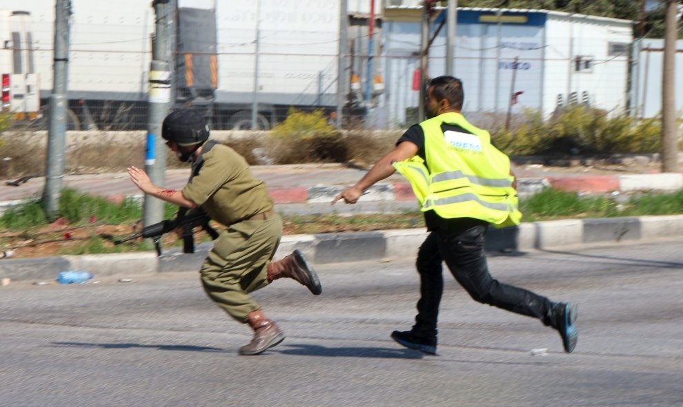 Un atacante palestino, vestido de periodista, apuñala a un soldado israelí antes de caer fulminado por los disparos del Ejército hebreo cerca de la ciudad de Hebrón, en Cisjordania.- REUTERS / Jameel Salhab