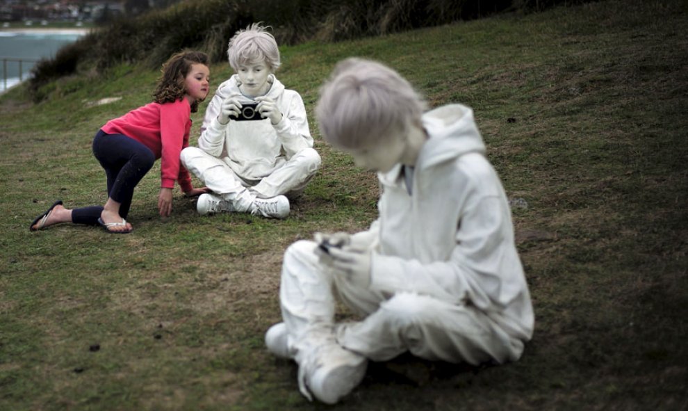 Una niña observa de cerca dos esculturas en Sidney. REUTERS/Jason Reed