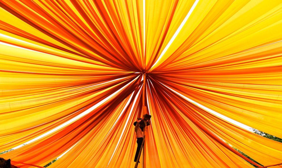 Un electricista coloca los cables en una carpa durante el Festival Nacional de la Cultura de la India, en Nueva Delhi.-  SAJJAD HUSSAIN (AFP)