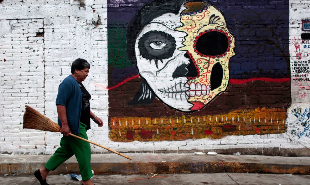 Una mujer lleva una escoba para limpiar las tumbas en el cementerio de Tixtla, estado de Guerrero, México, durante la celebración del Día de Todos los Santos el 1 de noviembre de 2015. AFP PHOTO / Pedro PARDO