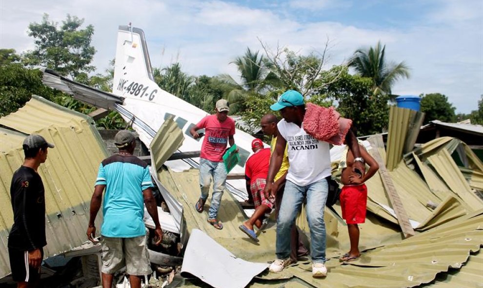 Un grupo de personas observa el lugar donde se estrelló un pequeño avión que trasladaba al equipo de béisbol del departamento colombiano de Antioquia, en los alrededores del municipio de Acandí, en la región del Chocó (oeste de Colombia). La aeronave acci