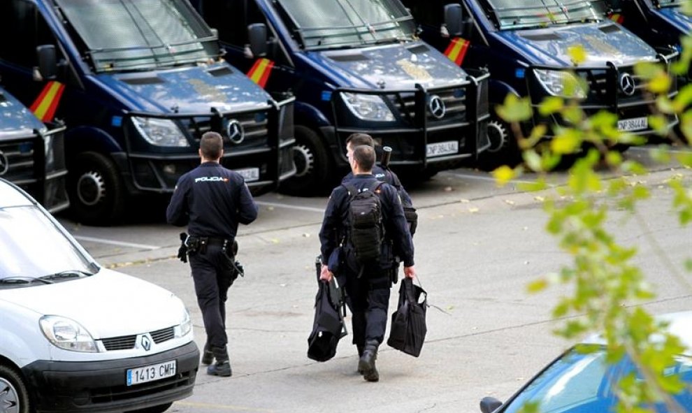 Agentes de la Policía Nacional se dirigen hacia los furgones policiales. EFE/Víctor Lerena