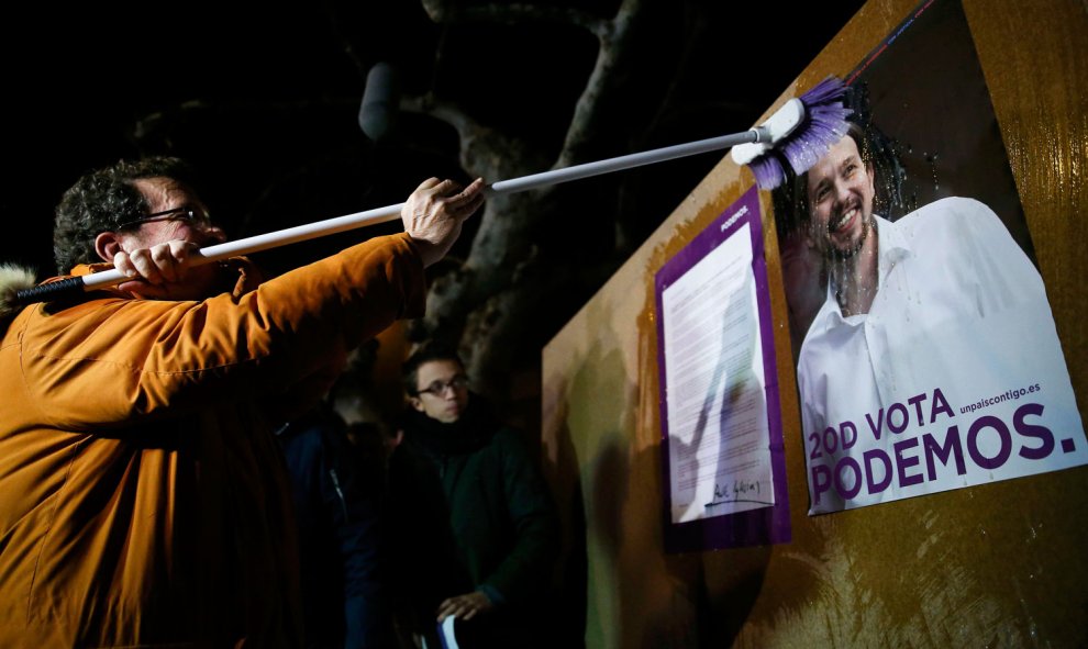 Javier Iglesias, el padre de Pablo Iglesias, pega un cartel de Podemos con la imagen de su hijo en Villaralbo (Zamora). / REUTERS