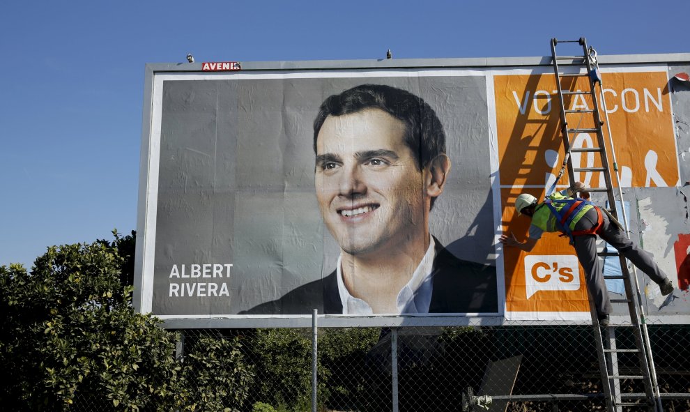 Un operario termina de colocar un cartel electoral de Albert Rivera en Gelves, cerca de Sevilla. REUTERS/Marcelo del Pozo