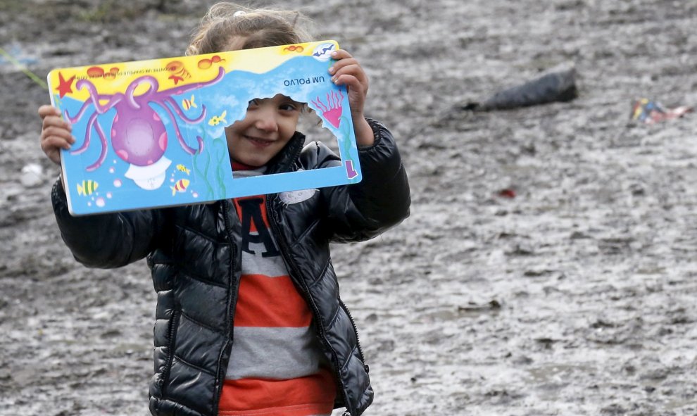 Una niña procedente del Kurdistán mira a través de una ventana de su libro infantil en un campamento provisional para refugiados de procedentes de Irak, Kurdistán, Irán y Siria, cerca de Dunkerque (Francia). REUTERS / Pascal Rossignol