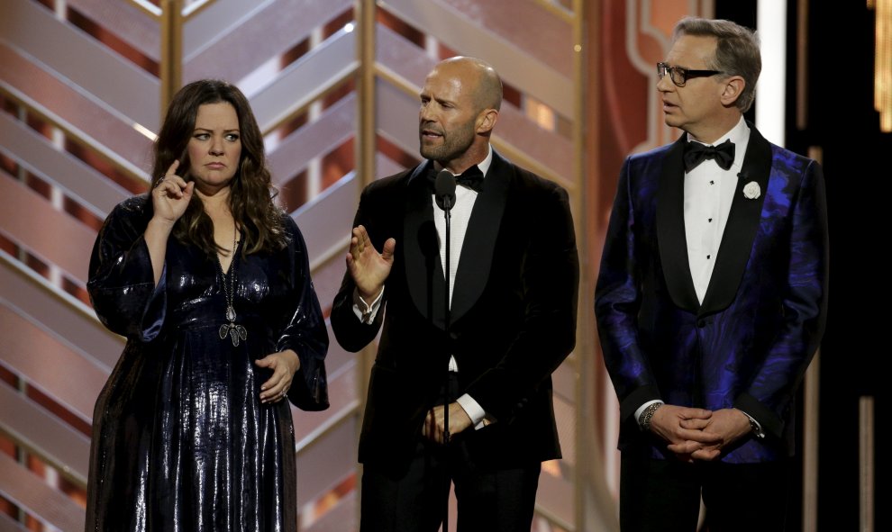 Melissa McCarthy (i) Jason Statham (c) y Paul Feig (d) se ven en el escenario en la 73ª gala de los Premios Globo de Oro en Beverly Hills , California. REUTERS / Paul Drinkwater