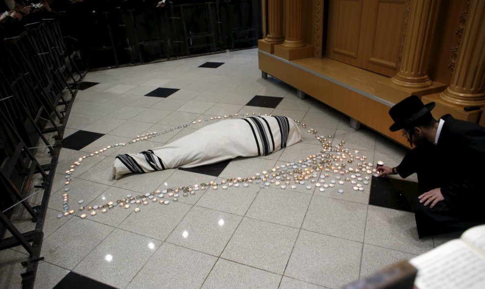 Un judío ultra-ortodoxo coloca una vela al lado del cuerpo del rabino Yochanan Sofer, el líder espiritual de la dinastía Erlau, durante su entierro en Jerusalén. REUTERS/Ronen Zvulun