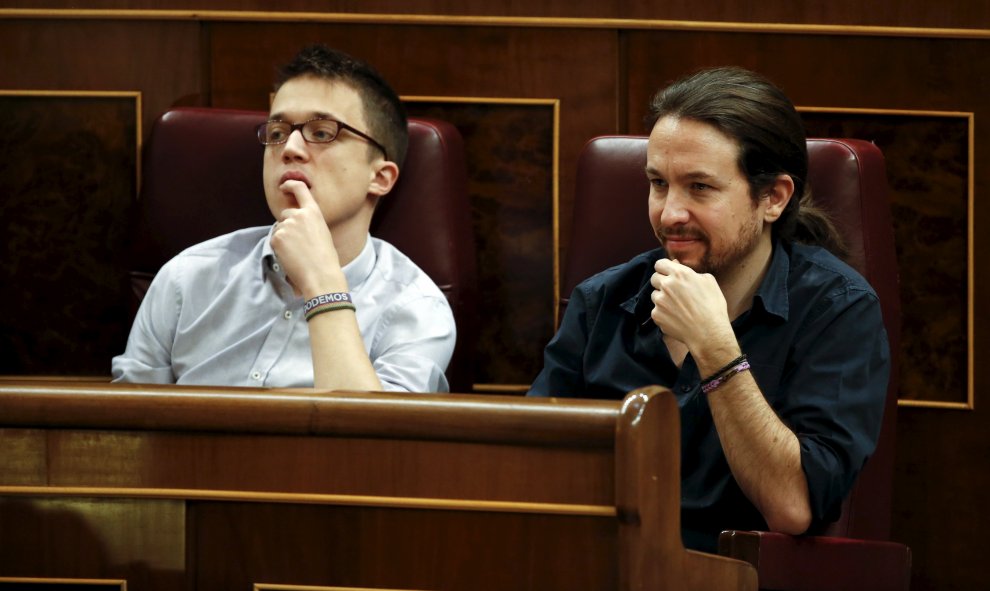 El secretario general de Podemos, Pablo Iglesias, escucha el discurso de Pedro Sáchez junto a Ínigo Errejón.- REUTERS