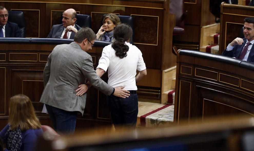 El líder de Podemos, Pablo Iglesias, y el de En Comú Podemo, Xavier Domenech, se saludan al volver a sus asientos.- REUTERS/Andrea Comas