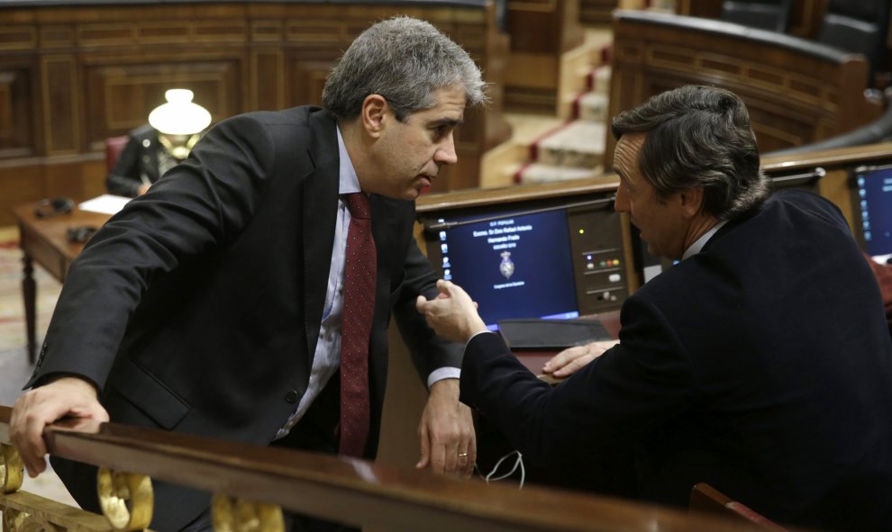 El portavoz de Democràcia i Llibertat (DiL), Francesc Homs (i), conversa con el portavoz del PP, Rafael Hernando (d), durante la sesión de la tarde de la segunda jornada del debate de investidura del secretario general del PSOE, Pedro Sánchez, que se cele