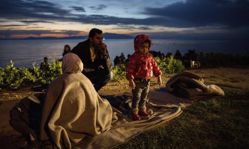 Una familia de refugiados descansa tras llegar a la isla de Lesbos tras cruzar el mar desde Turquía en el puerto de Mytilene (Grecia) hoy, 9 de marzo de 2016. EFE/Kay Nietfeld