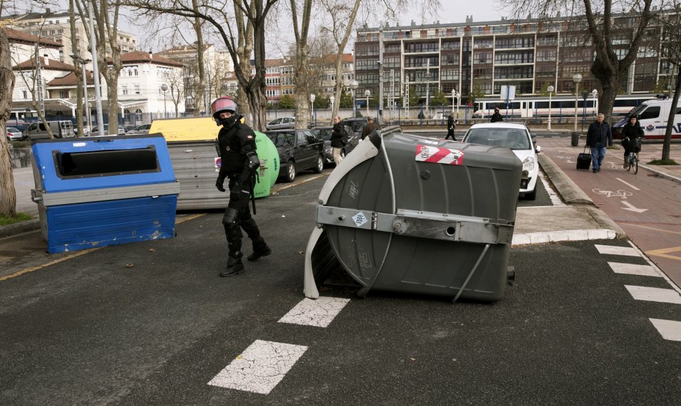 Agentes de la ertzaintza retiran una barricada colocada por grupos de estudiantes que han cortado el tráfico durante los incidentes que se han registrado hoy en el campus alavés de la Universidad del País Vasco (UPV/EHU) en Vitoria, en donde ha tenido lug