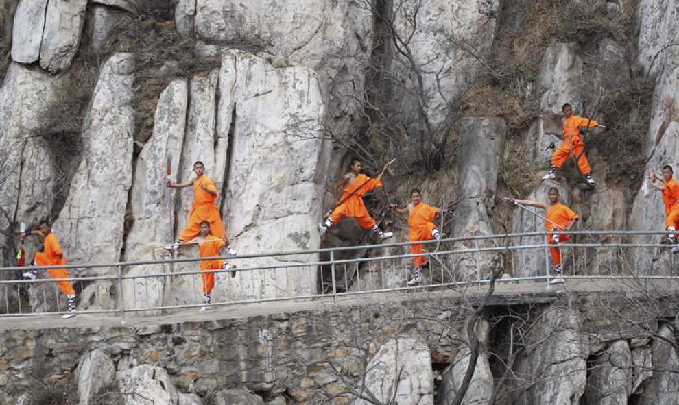 Practicantes de Kung fu de una escuela local de artes marciales demuestran sus habilidades en un acantilado cerca del Templo Shaolin en Dengfeng, China. EFE