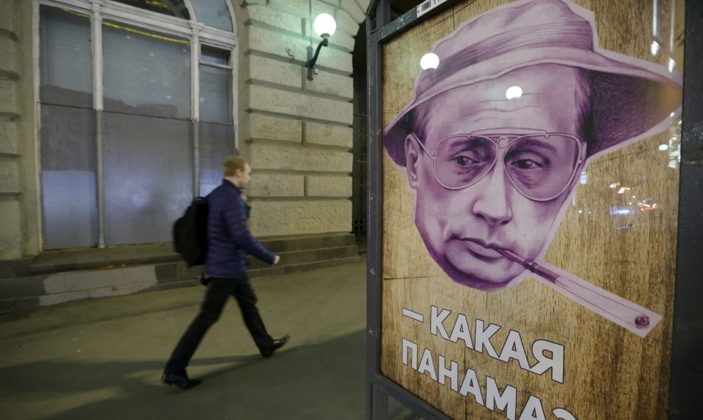 Un hombre pasa junto a un cartel que representa al presidente ruso, Vladimir Putin, junto a las palabras "¿Qué Panamá?" en una parada de autobús en Moscú. REUTERS / Sergei Karpukhin