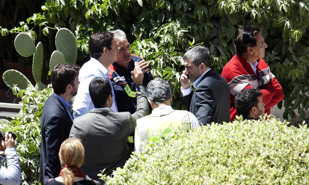 El presidente del Gobierno de Canarias, Fernando Clavijo (con el móvil) y el presidente del Cabildo de Tenerife, Carlos Alonso (i), se desplazaron esta tarde al lugar en el que un edificio se ha derrumbado en el centro de Los Cristianos en el municipio ti