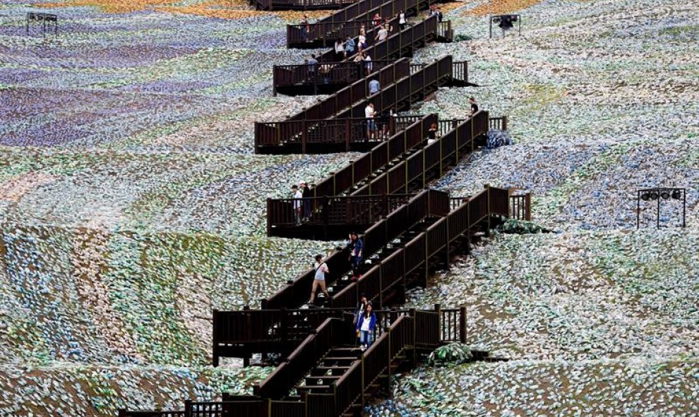 Varias personas pasean por el mosaico que representa 'La noche estrellada' del pintor holandés Vincent Van Gogh y que ha sido reconstruido con botellas de plástico desechadas en Keelung (Taiwán). EFE/Ritchie B. Tongo