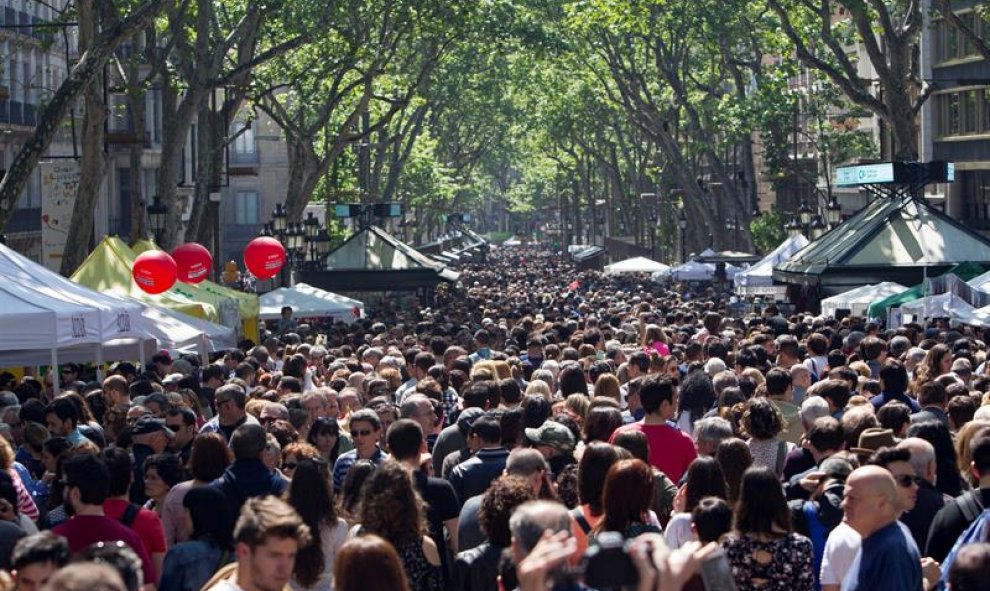 Las calles se llenan de miles de ciudadanos en busca de rosas y libros para regalar, y que también da cabida a centenares de iniciativas culturales, musicales, gastronómicas o solidarias. EFE/Quique García