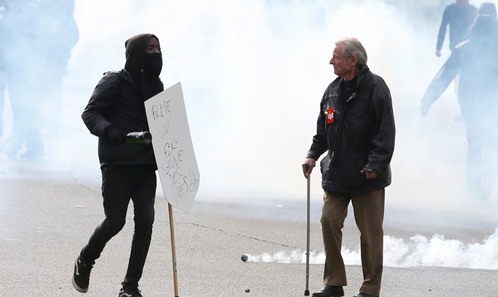 Manifestantes rodeados de una nube de gas lacrimógeno durante una manifestación en contra de la propuesta de la ley laboral francesa en París. REUTERS/Charles Platiau