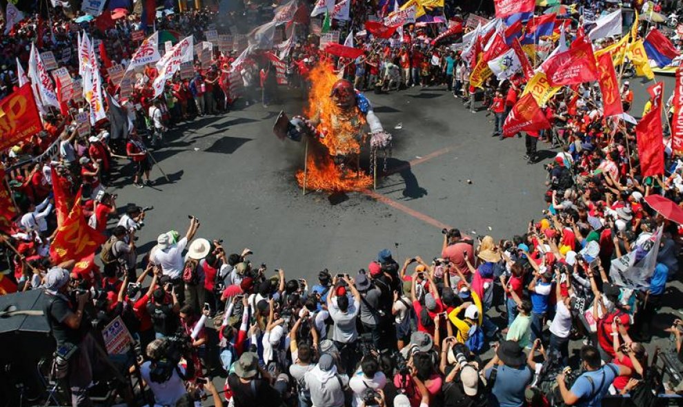 Los manifestantes filipinos queman una estatua en representación del presidente de Filipinas , Benigno Aquino III,  durante una protesta con motivo del Día Internacional del Trabajo en Manila, Filipinas. EFE/EPA/MARK R. CRISTINO