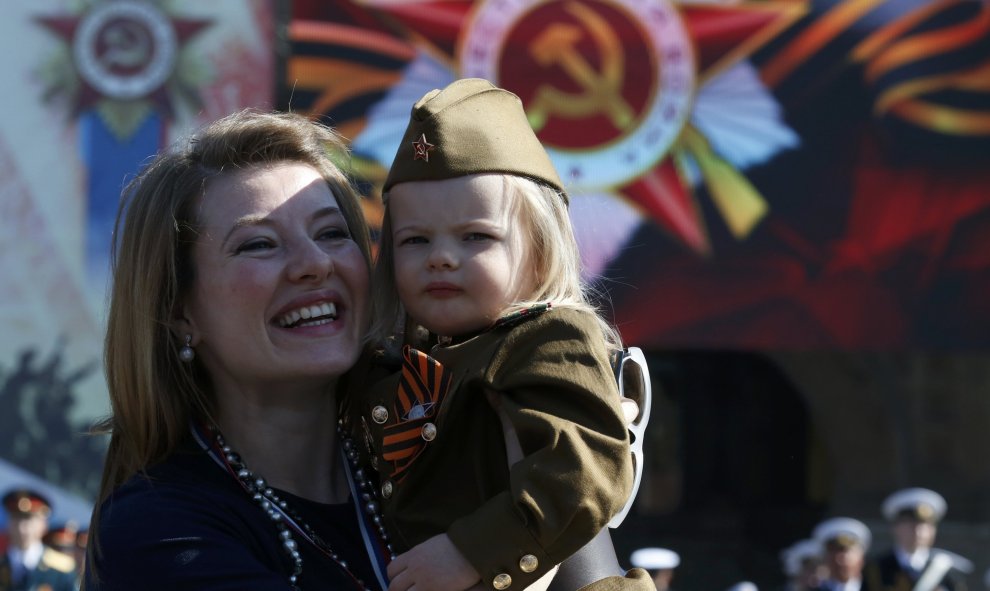 Una mujer con su hija vestida con el uniforme del Ejército soviético asiste al desfile en la Plaza Roja que conmemora el 71 aniversario de la victoria sobre el Ejército nazi. REUTERS/Grigory Dukor