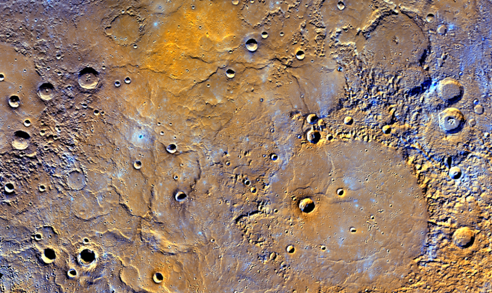 Una vista de las llanuras volcánicas del norte de Mercurio se muestran con colores realzados para resaltar los diferentes tipos de rocas en la superficie del planeta. NASA/JHUAPL/Carnegie Institution of Washington