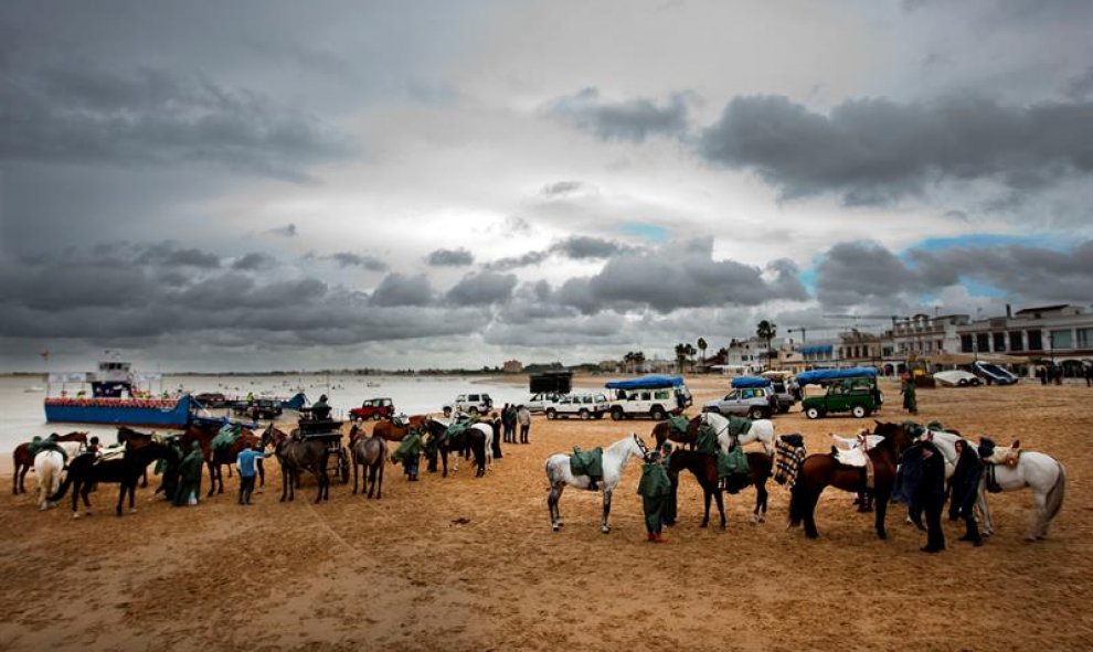 La hermandad rociera de Sanlúcar en el paso de Bajo de Guía en la localidad gaditana de Sanlúcar de Barrameda, dirección a Doñana, uno de los puntos más emblemáticos del camino donde se concentran romeros, caballos, carretas y vehículos embarcando para cr