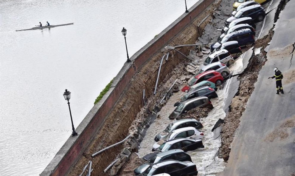 Varios vehículos aparecen engullidos por un socavón cerca del famoso Puente Viejo a orillas del río Arno, en el centro de la ciudad italiana de Florencia (Italia). EFE/Maurizio Degl' Innocenti