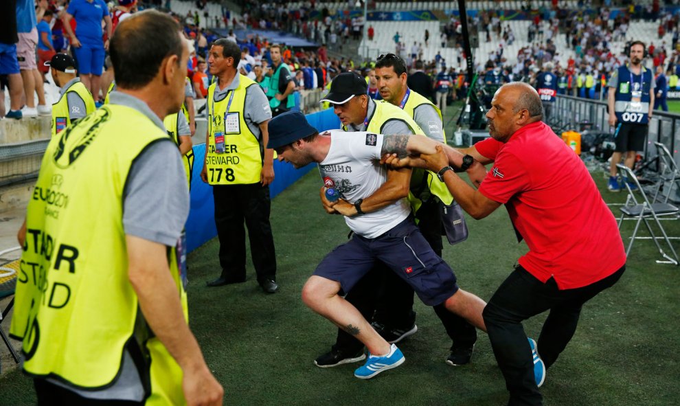 Miembros de la seguridad sujetan a un hincha tras el partido Inglaterra-Rusia. /REUTERS