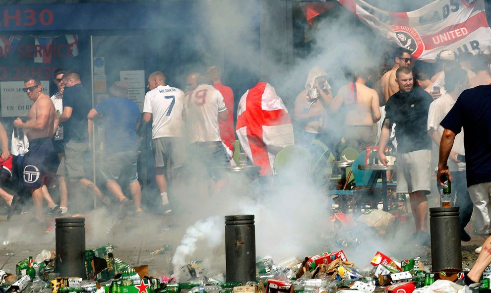 Hinchas ingleses se apartan tras lanzar un petardo en una calle llena de desperdicios y botellas de cerveza vacías. /REUTERS