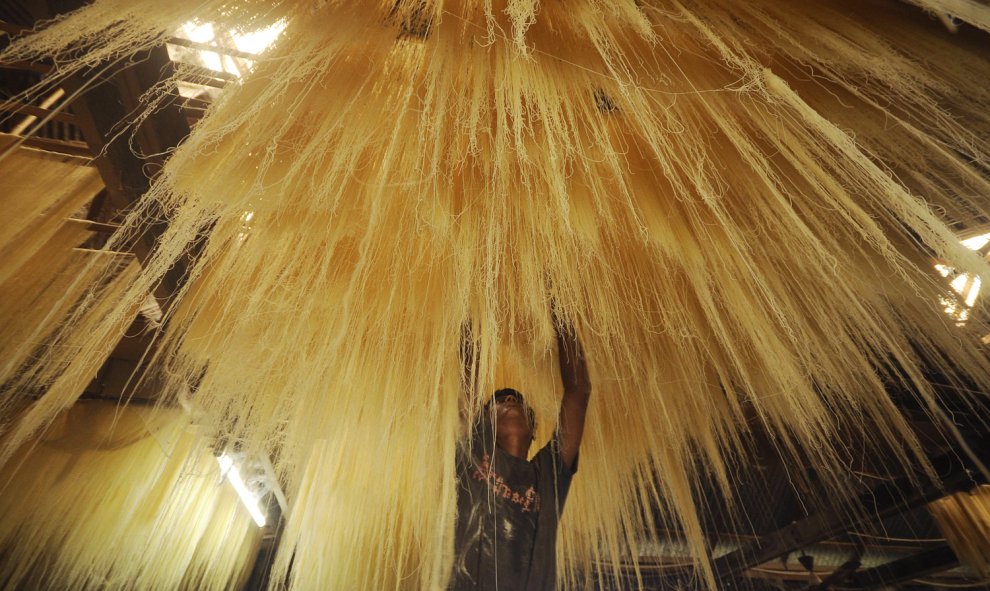 Un trabajador indio seca 'seviiyan', un alimento que se utiliza para la preparación del tradicional plato dulce sheerkhurma durante el mes del Ramadán, en una fábrica en Agartala, en India. Arindam DEY / AFP