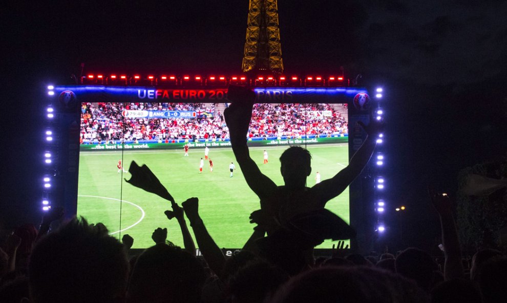 Hinchas ingleses ven en una pantalla gigante el partido de fútbol de la Eurocopa 2016 entre Inglaterra y Rusia frente de la Torre Eiffel en París. GEOFFROY HASSELT VAN DER / AFP